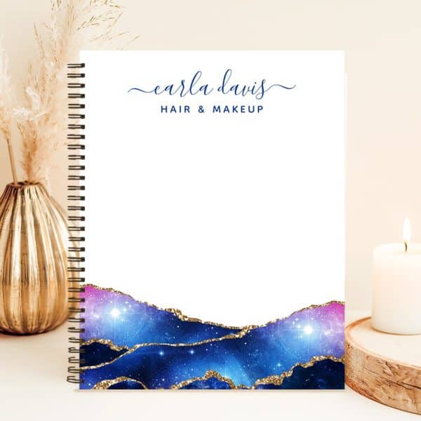 Spiral-Bound Notebook With Earla Davis Hair &Amp; Makeup Logo; Bottom Features A Galaxy Design With Gold Accents.