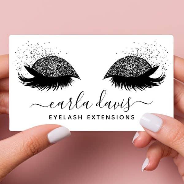A Business Card Featuring A Pair Of Eyes With Glitter Eyeshadow And Long Lashes. The Name Carla Davis Eyelash Extensions Is Below.