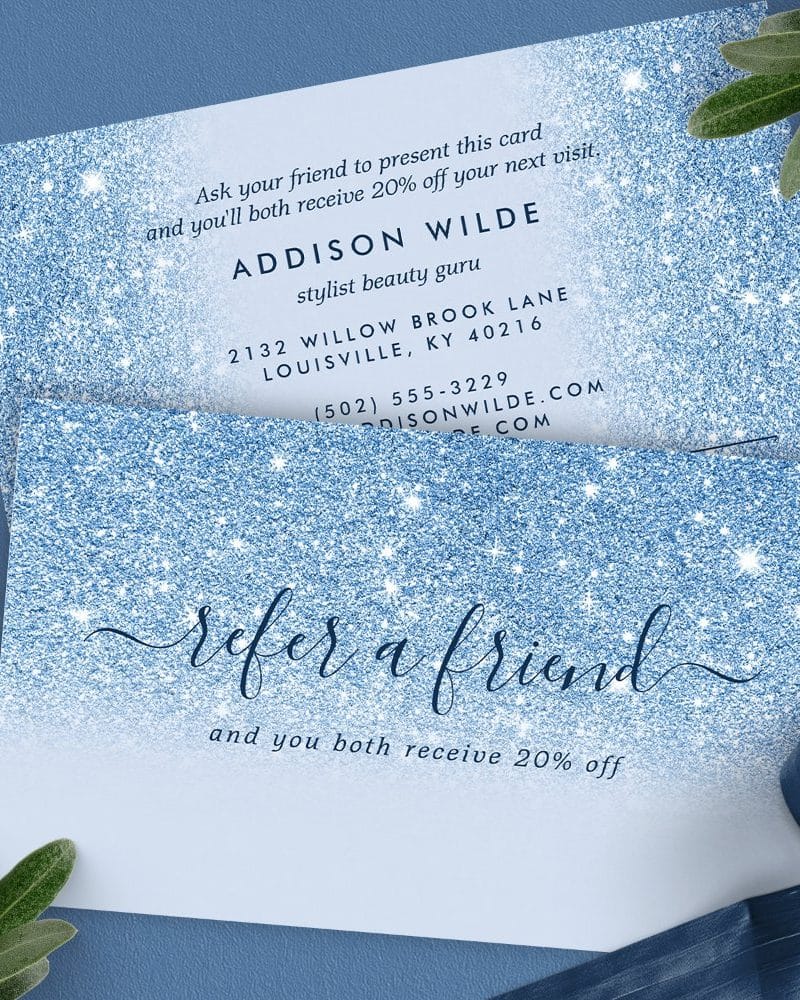 Blue glitter referral card offering 20% off for both referrer and friend. Contact information for Addison Wilde, stylist, is included.