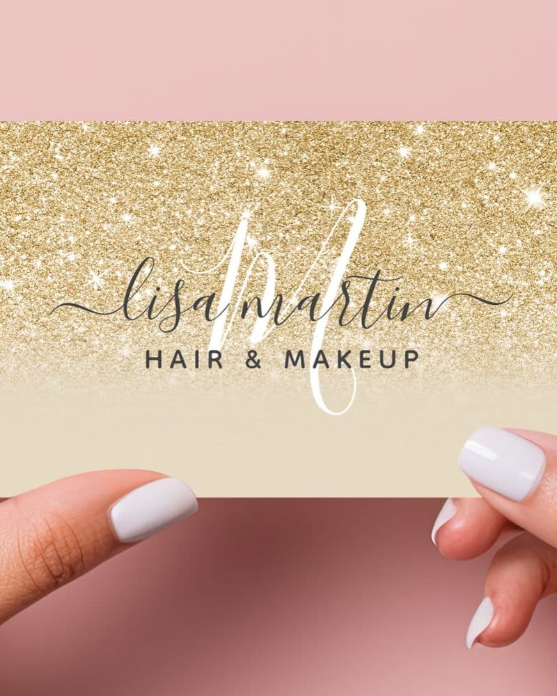 Two hands hold up a gold glitter business card that says Lisa Martin Hair & Makeup.