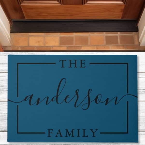 Teal Doormat With The Words The Anderson Family In A Black Sans-Serif Font.