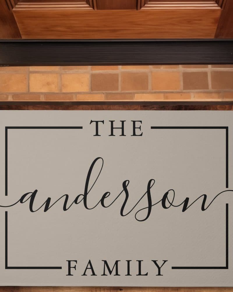 Tan doormat with the text The Anderson Family in a simple black frame.