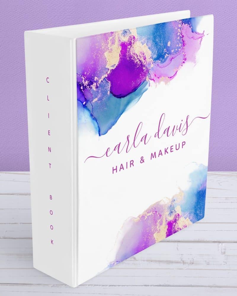 White client book with purple, blue, and gold alcohol ink design and Carla Davis Hair & Makeup text.