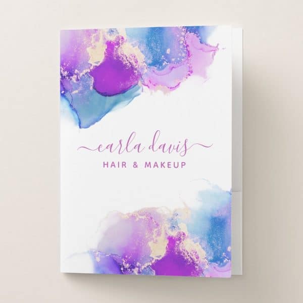 A Pocket Folder Featuring An Abstract Design Of Purple, Blue, And Gold Watercolor, With The Name Carla Davis Hair &Amp; Makeup.