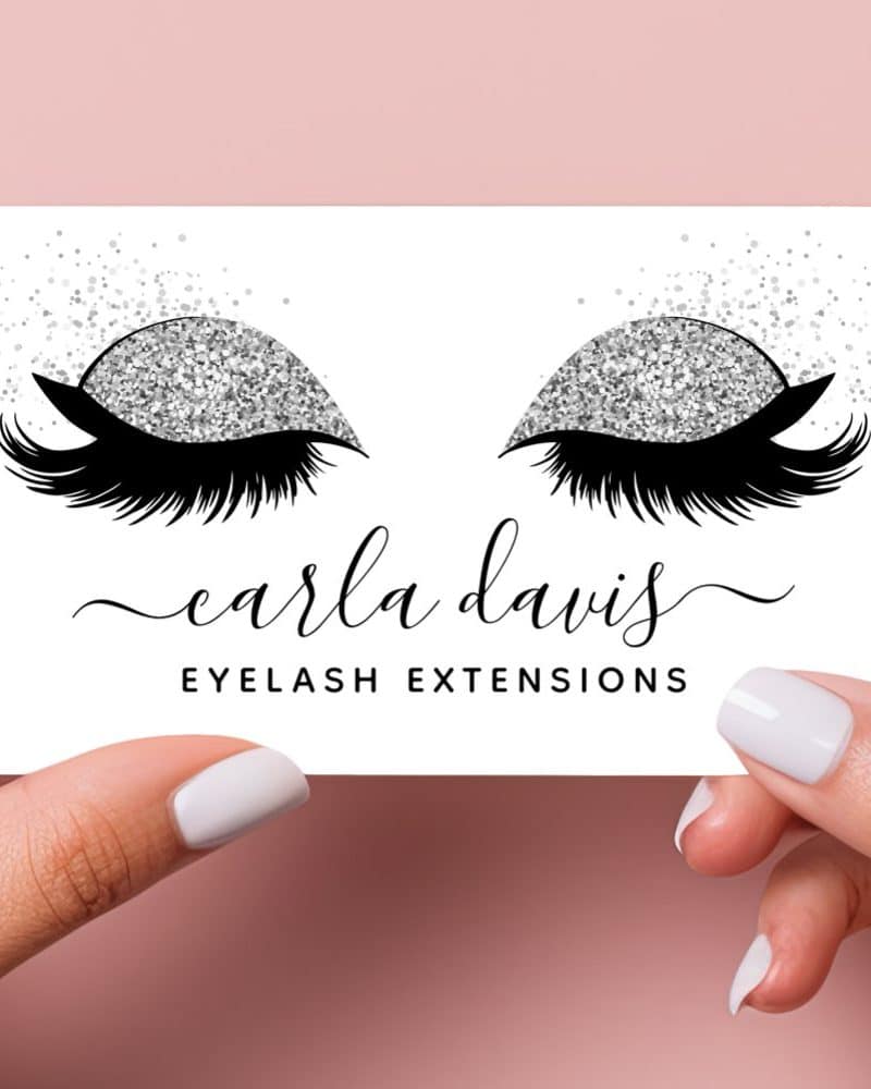 A business card featuring a pair of eyes with long lashes and silver glitter eyeshadow. The text Carla Davis Eyelash Extensions is below.