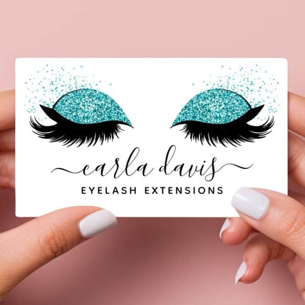 A Business Card For Carla Davis Eyelash Extensions Featuring A Pair Of Eyes With Teal Glitter Eyeshadow And Long Lashes.