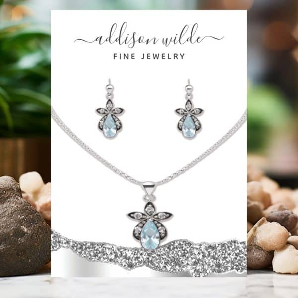Silver Necklace And Earrings Set Featuring Light Blue Teardrop Gemstones.