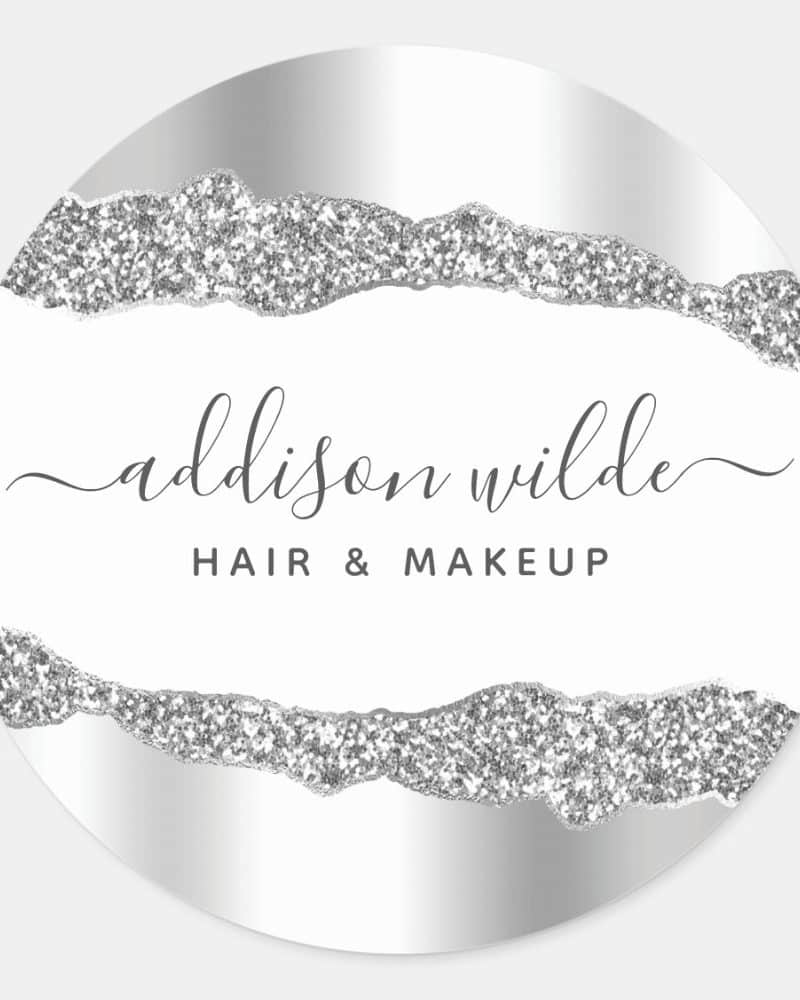 Circular silver and white logo featuring the name Addison Wilde Hair & Makeup in elegant script. Silver glitter accents the design.