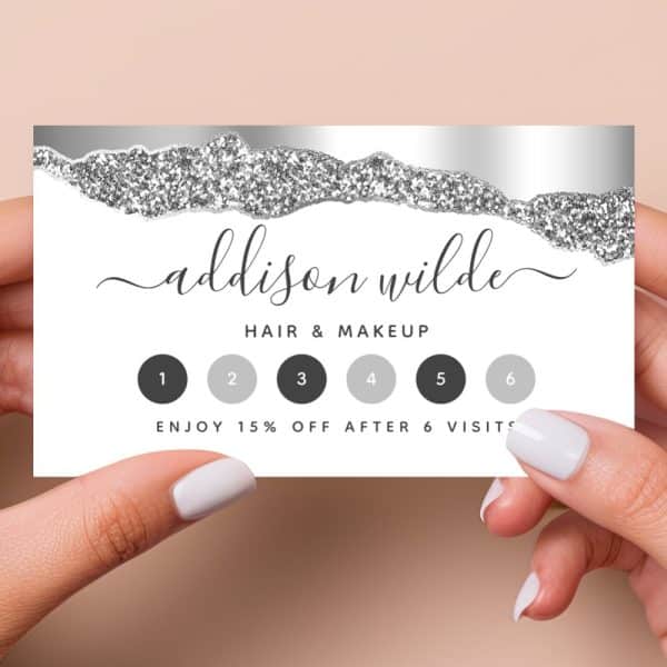 A Silver And White Loyalty Card For Addison Wilde Hair &Amp; Makeup. The Card Has A Glitter Design And Six Spaces To Be Punched For Visits, Offering A 15% Discount After Six Visits.