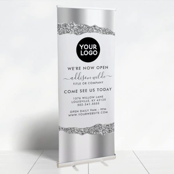 Silver And Gray Retractable Banner Announcing A New Business Opening, Featuring A Sparkly Design Element.