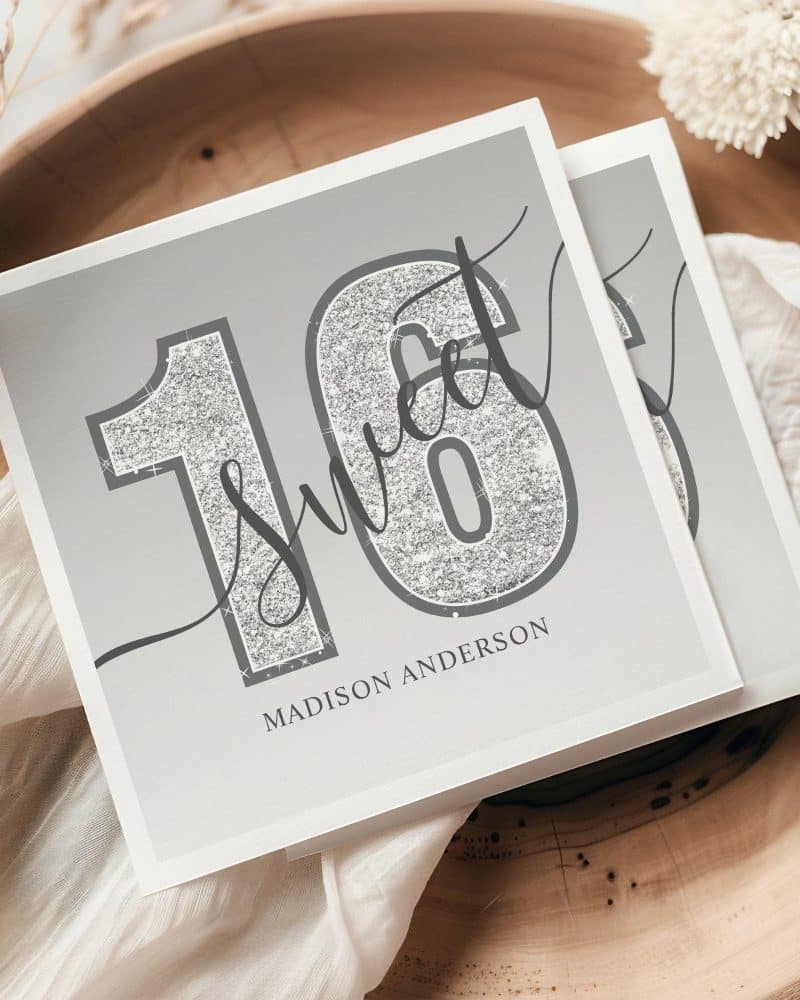 Silver glitter sixteen and the words Sweet Sixteen on a gray background. Madison Anderson is printed below.