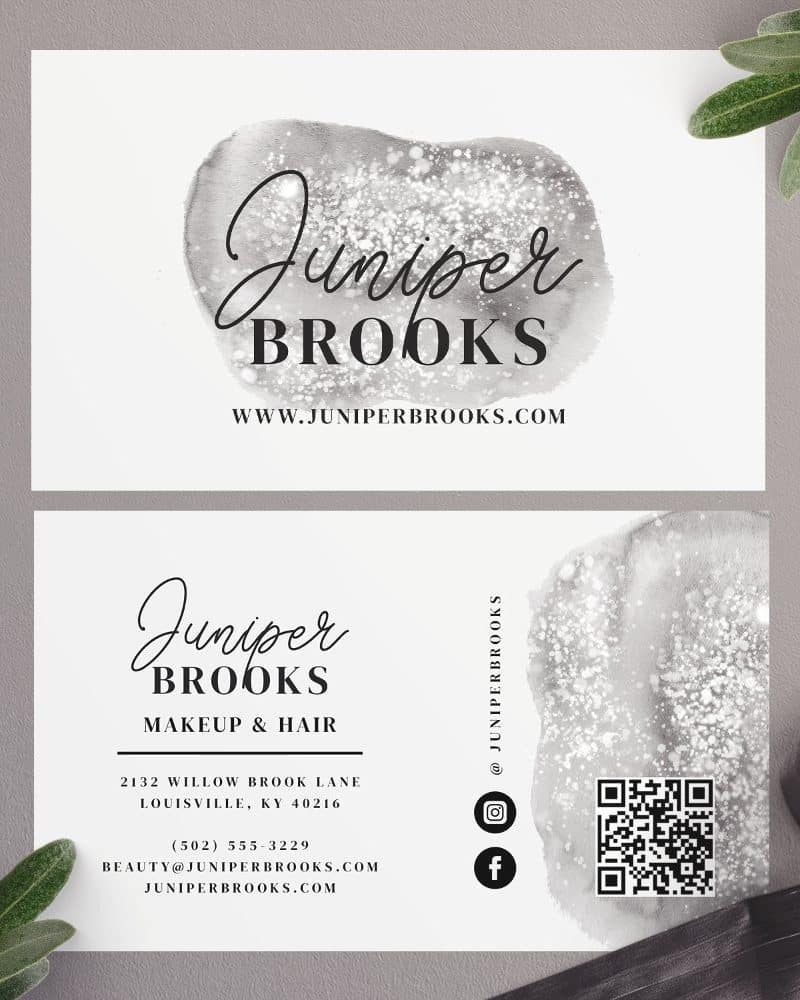 A pair of business cards for Juniper Brooks Makeup & Hair, featuring a gray watercolor design and contact information.
