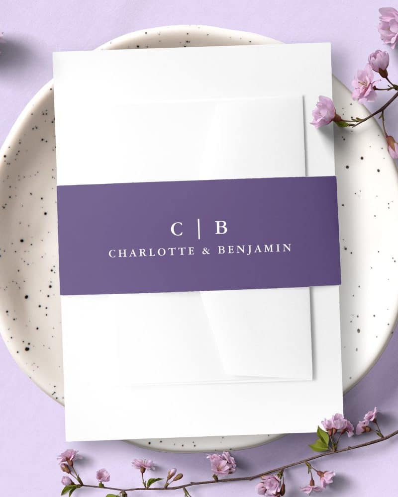 Wedding invitation with a purple band featuring the initials CB and the names Charlotte & Benjamin.