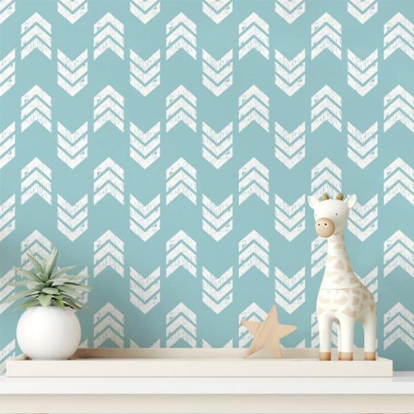 A Teal Wall With A Repeating Pattern Of White Chevron Arrows, Decorated With A Small Giraffe Toy And A Potted Plant On A Shelf.