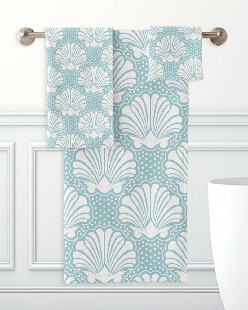 Light blue bath towels with a white seashell pattern.