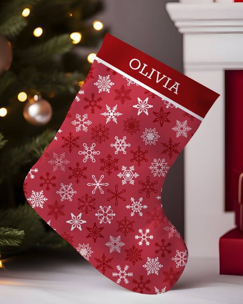 Red Christmas stocking with a white snowflake pattern and the name Olivia.