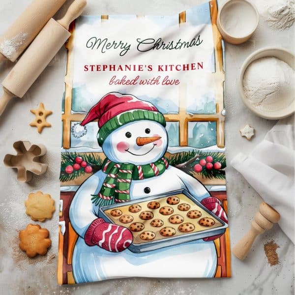 Christmas Kitchen Towel Featuring A Snowman Holding A Pan Of Cookies. The Towel Is Personalized With A Name And Merry Christmas Message.