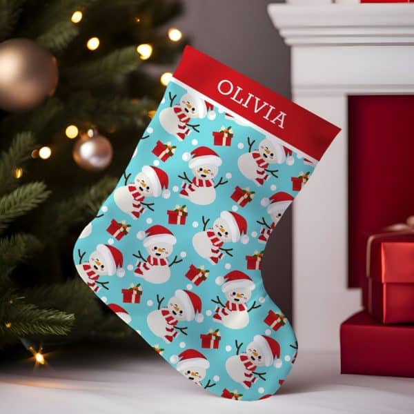 Personalized Christmas Stocking With A Light Blue Background And A Repeating Pattern Of Snowmen Wearing Red Hats And Scarves. The Stocking Is Labeled Olivia.
