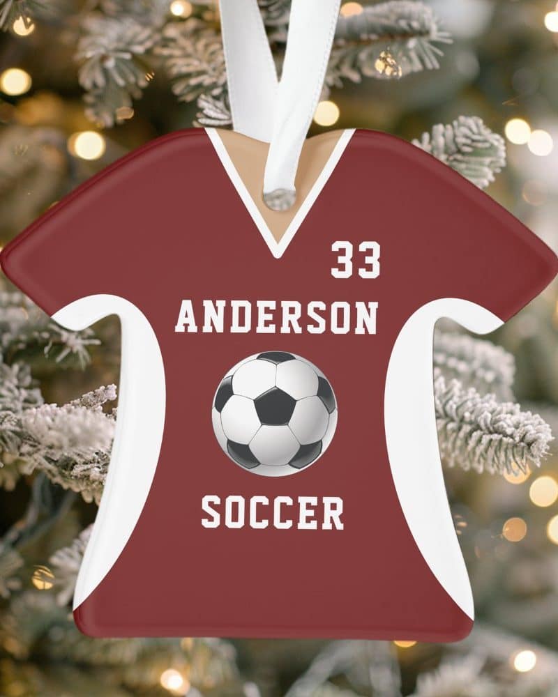 A maroon soccer jersey-shaped Christmas ornament with the name Anderson, number 33, and a soccer ball.