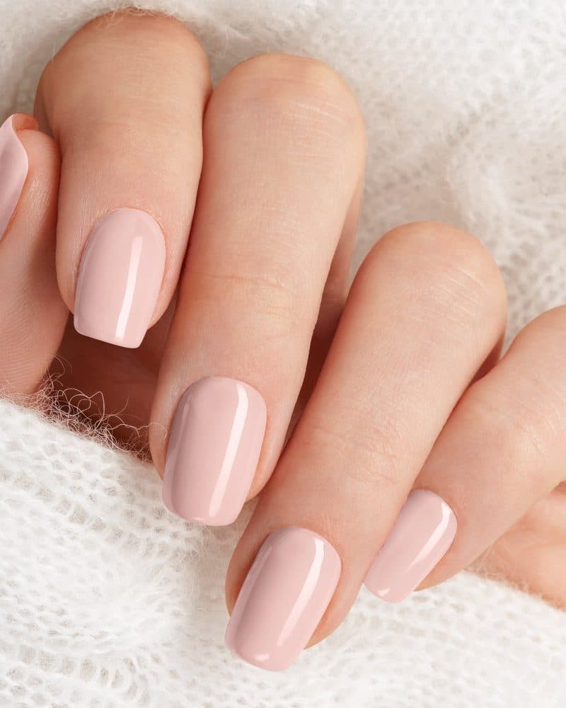 Close-up of a hand with light pink nails.