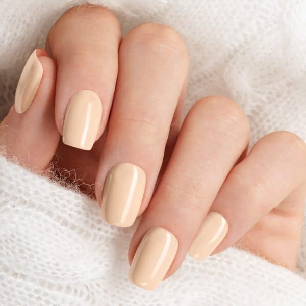Close-Up Of A Hand With Light Beige Nail Polish.
