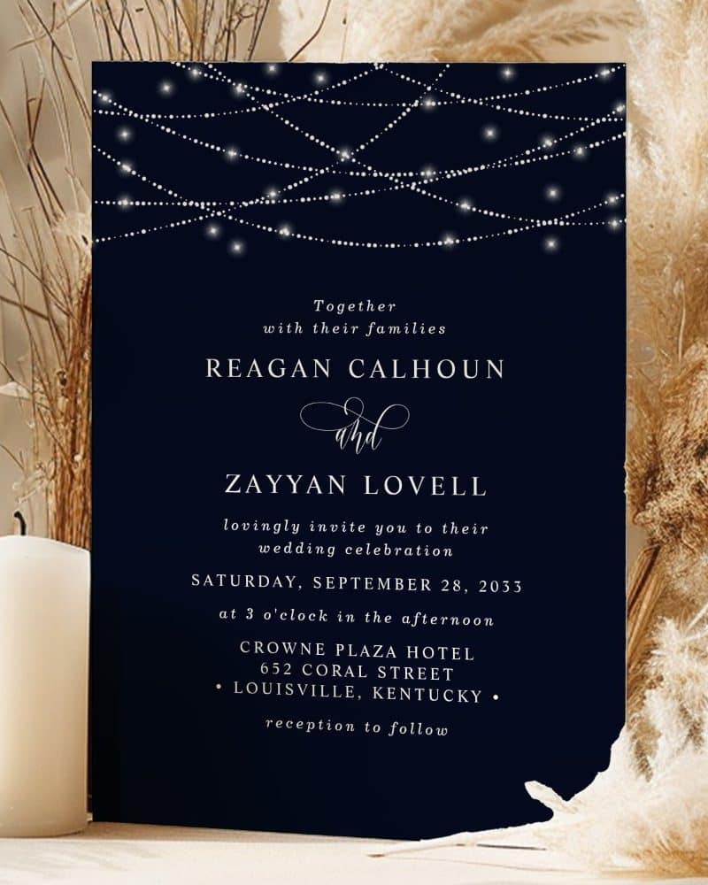 Wedding invitation for Reagan Calhoun and Zayyan Lovell, featuring a dark blue background with string lights.