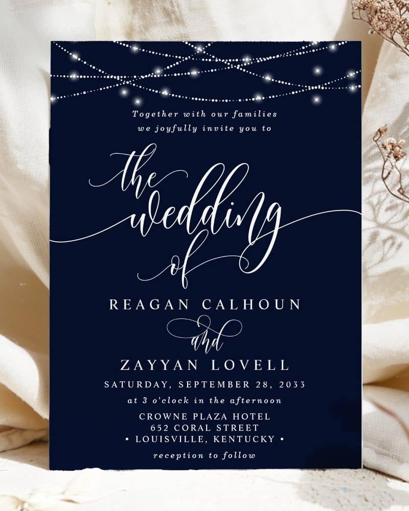 Wedding invitation for Reagan Calhoun and Zayyan Lovell, featuring string lights and elegant script.