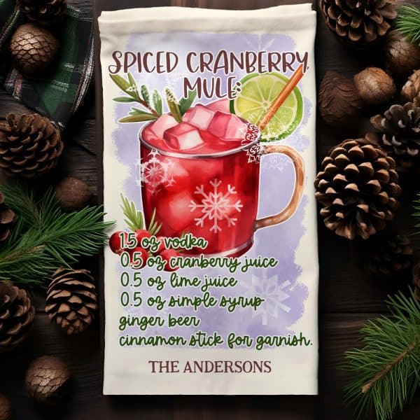 A Watercolor Illustration Of A Spiced Cranberry Mule Cocktail Recipe On A Kitchen Towel.