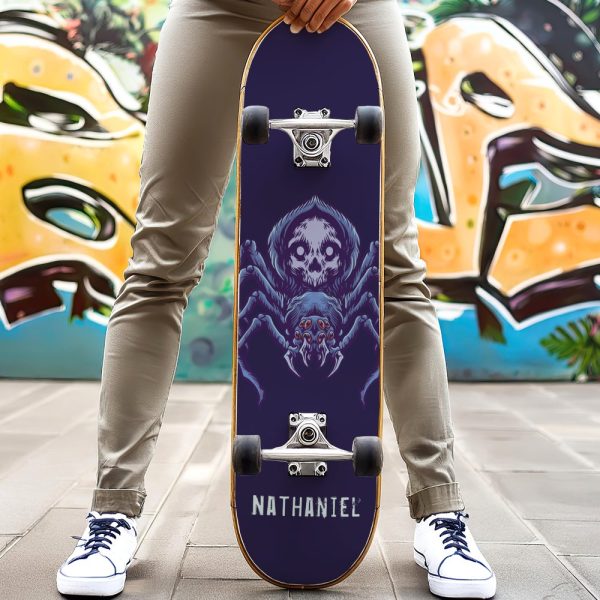 Person Holding A Skateboard With A Large, Skull-Faced Spider Graphic.