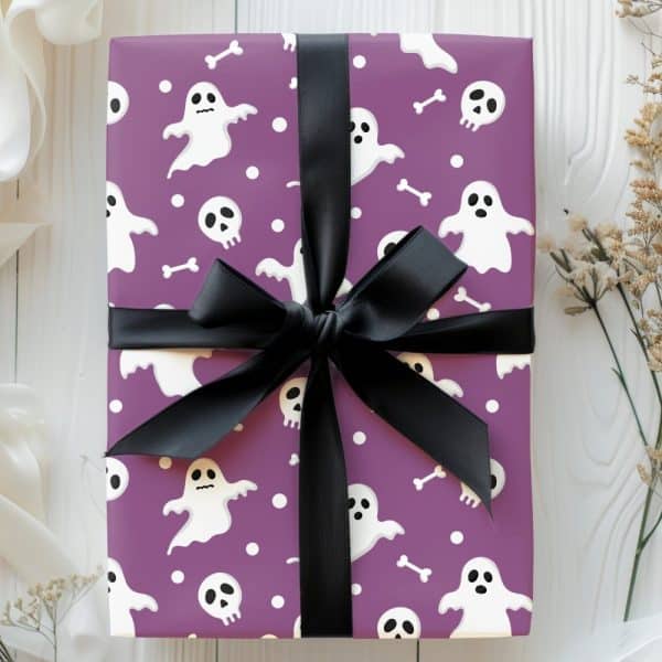 Purple Gift Box With A Black Ribbon, Decorated With A Halloween Pattern Of Ghosts And Skulls.