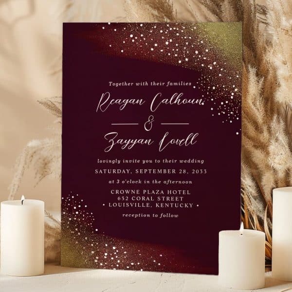 Burgundy Wedding Invitation With Gold And White Confetti, Announcing The Marriage Of Reagan Calhoun And Zayyan Lovell.