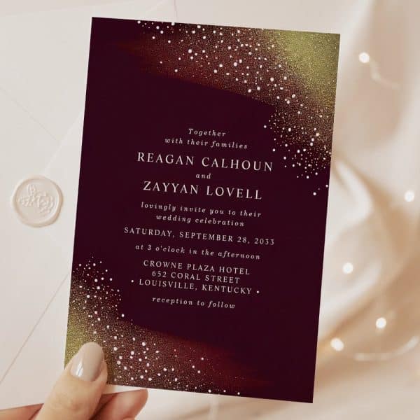 Wedding Invitation For Reagan Calhoun And Zayyan Lovell, Featuring A Dark Burgundy Background With Gold And Copper Glitter Accents.