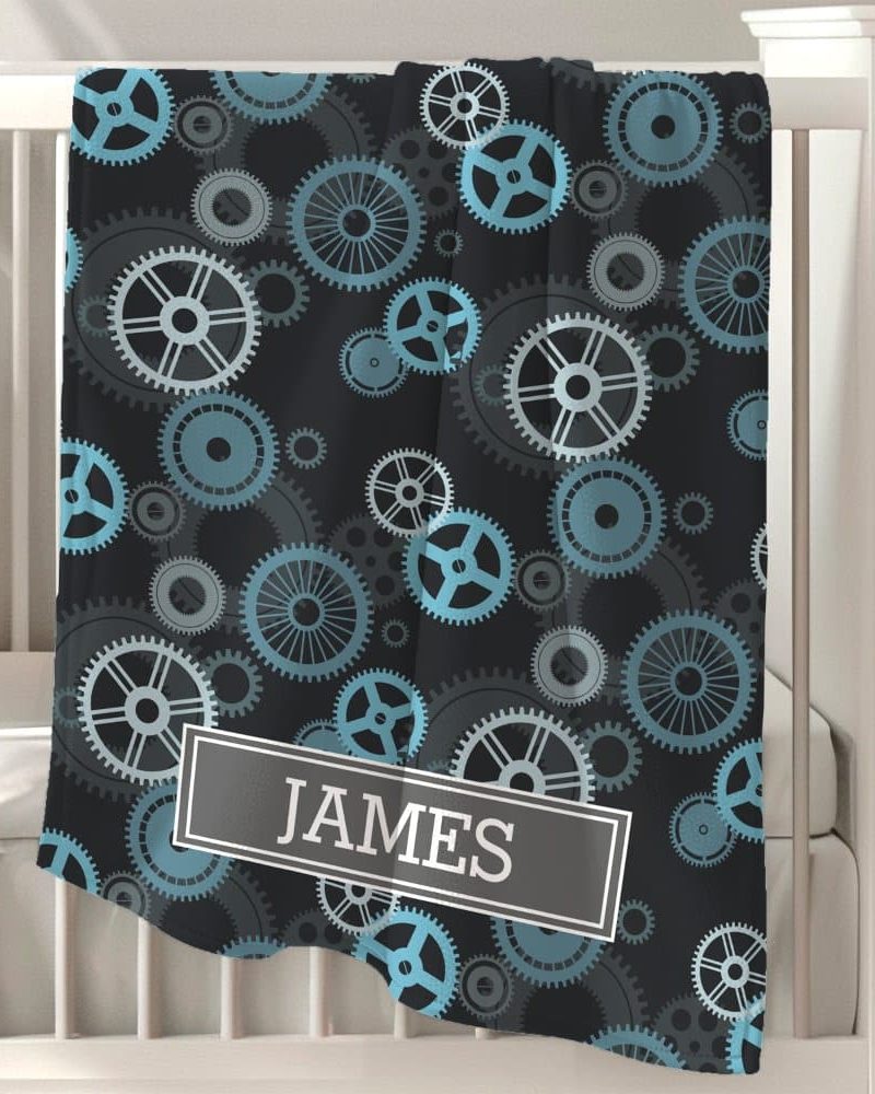 Black baby blanket with a teal and gray gear pattern and the name James.