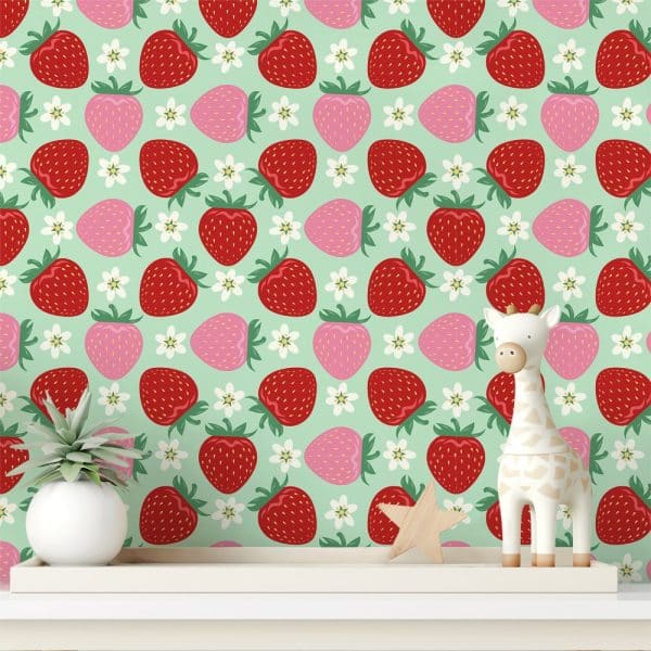 A Shelf Displays A Wooden Giraffe Toy And A Small Plant In Front Of A Wallpaper Featuring A Repeating Pattern Of Red And Pink Strawberries And White Flowers On A Mint Green Background.
