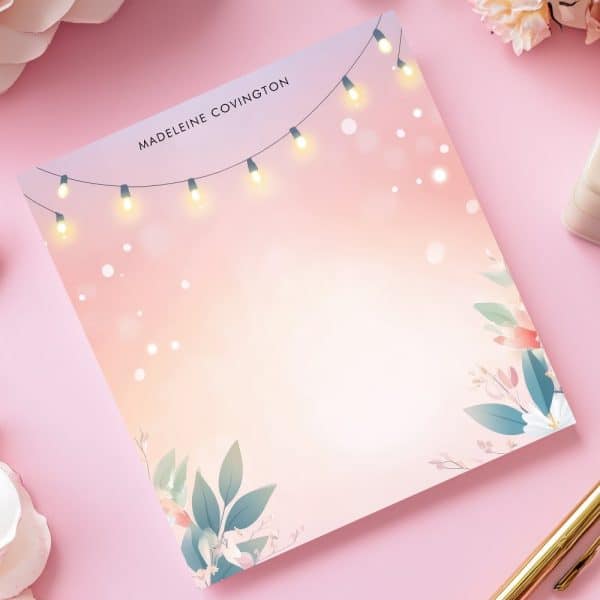 Personalized Notepad With Pink Floral Design, String Lights, And The Name Madeleine Covington.