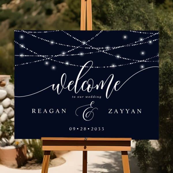A Dark Blue Wedding Welcome Sign With String Lights, The Names Reagan And Zayyan, And The Date September 28, 2033.