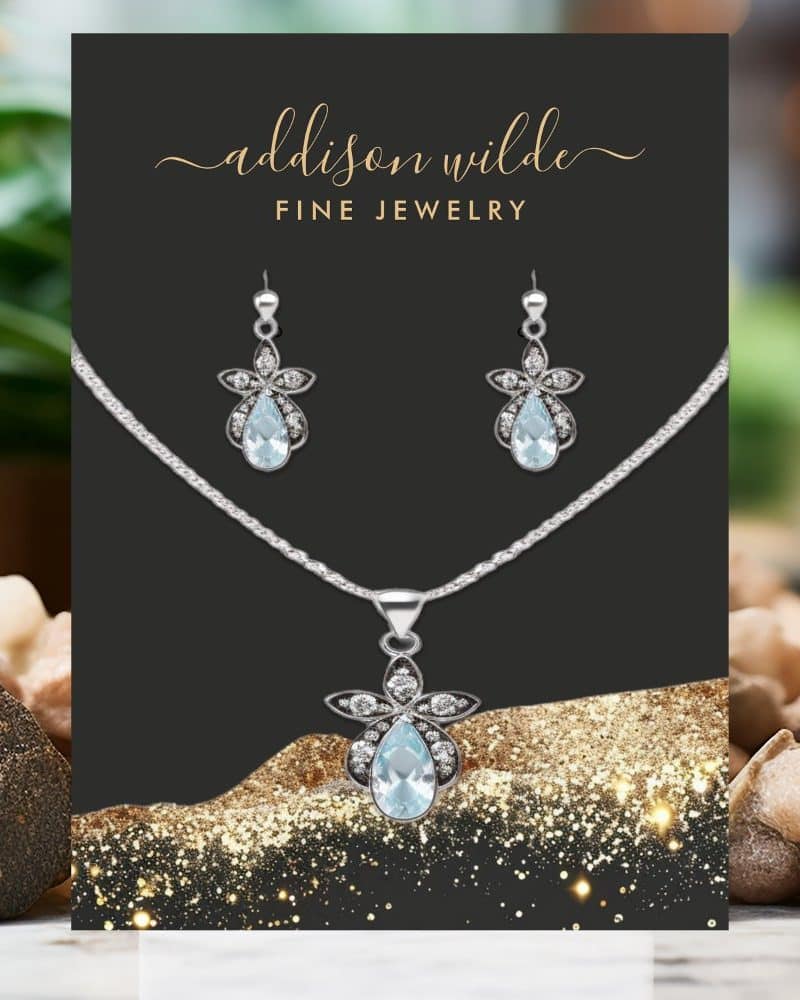 Aquamarine pendant necklace and earring set with silver floral accents.
