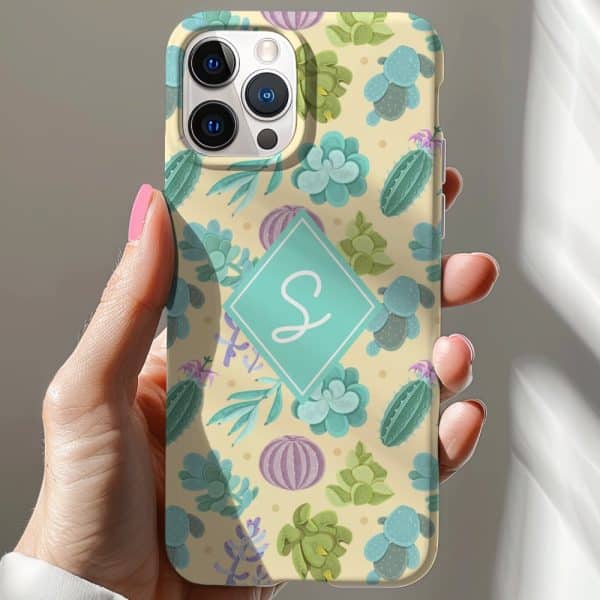 Hand Holding A Pale Yellow Iphone Case Featuring A Pattern Of Cacti And Succulents, And A Teal Monogram.