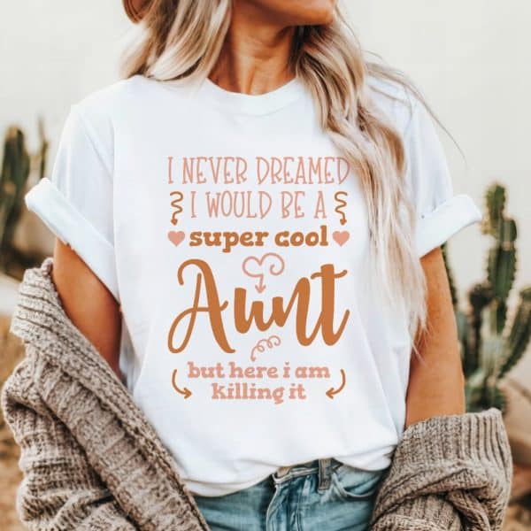 Woman Wearing A White T-Shirt That Says, &Quot;I Never Dreamed I Would Be A Super Cool Aunt, But Here I Am Killing It.&Quot;