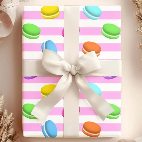 Gift Wrapped In Pink Striped Paper With A Pattern Of Colorful Macarons And A Cream-Colored Ribbon Bow.