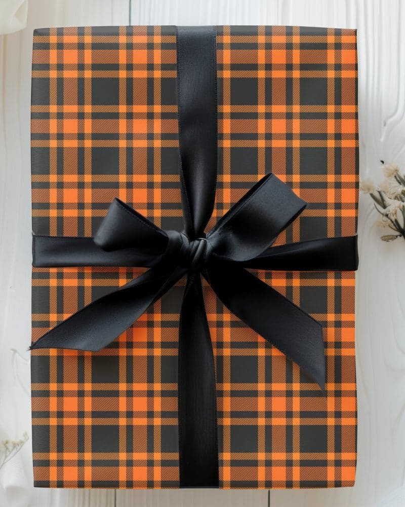 A gift wrapped in black and orange plaid paper with a black ribbon.