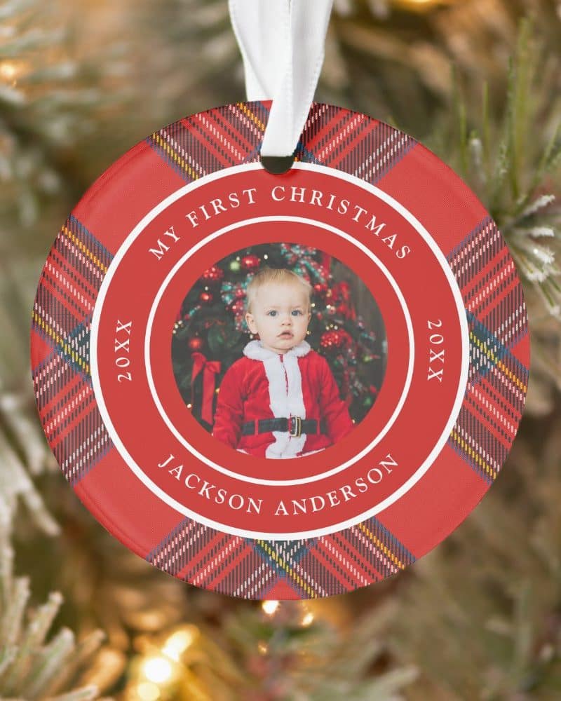 Round red plaid Christmas ornament featuring a photo of baby Jackson Anderson in a Santa suit; text reads My First Christmas 20XX.