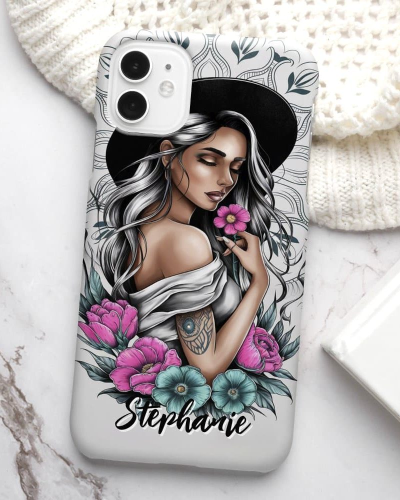 Phone case featuring a drawing of a woman with long gray hair wearing a hat, holding a flower, surrounded by flowers, with the name Stephanie at the bottom.
