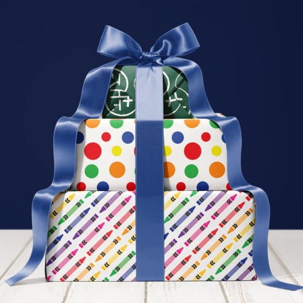 Stack Of Three Gifts Wrapped In Colorful Paper And Tied With A Blue Ribbon.