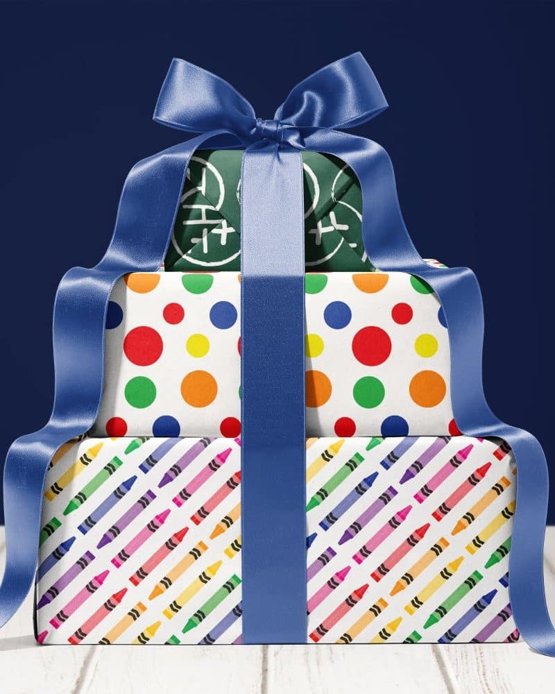 Stack of three gifts wrapped in colorful paper and tied with a blue ribbon.