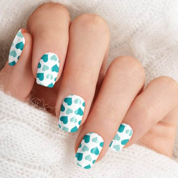 Close-Up Of A Hand With Fingernails Painted With A Teal Heart Pattern.