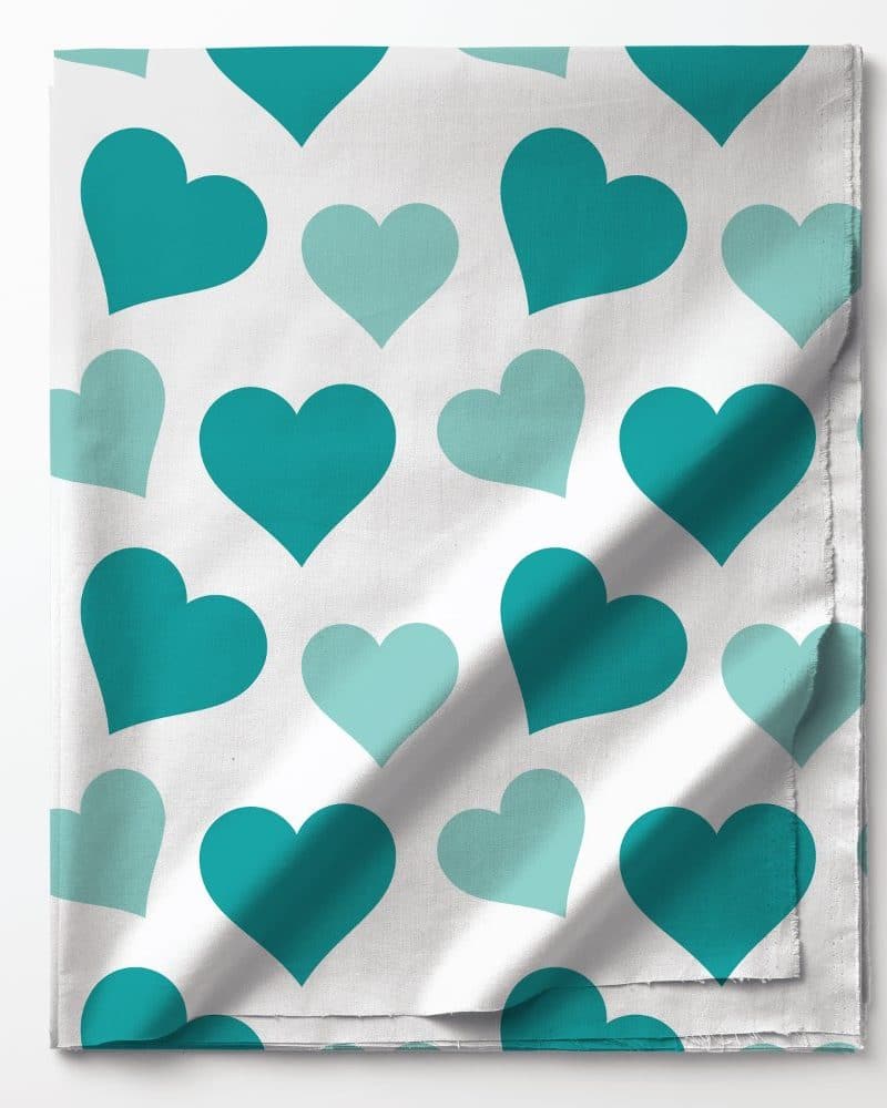 White fabric with teal and light teal hearts.