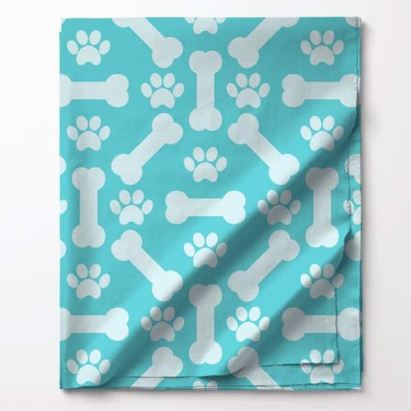 Teal Fabric With A Pattern Of White Bones And Paw Prints.