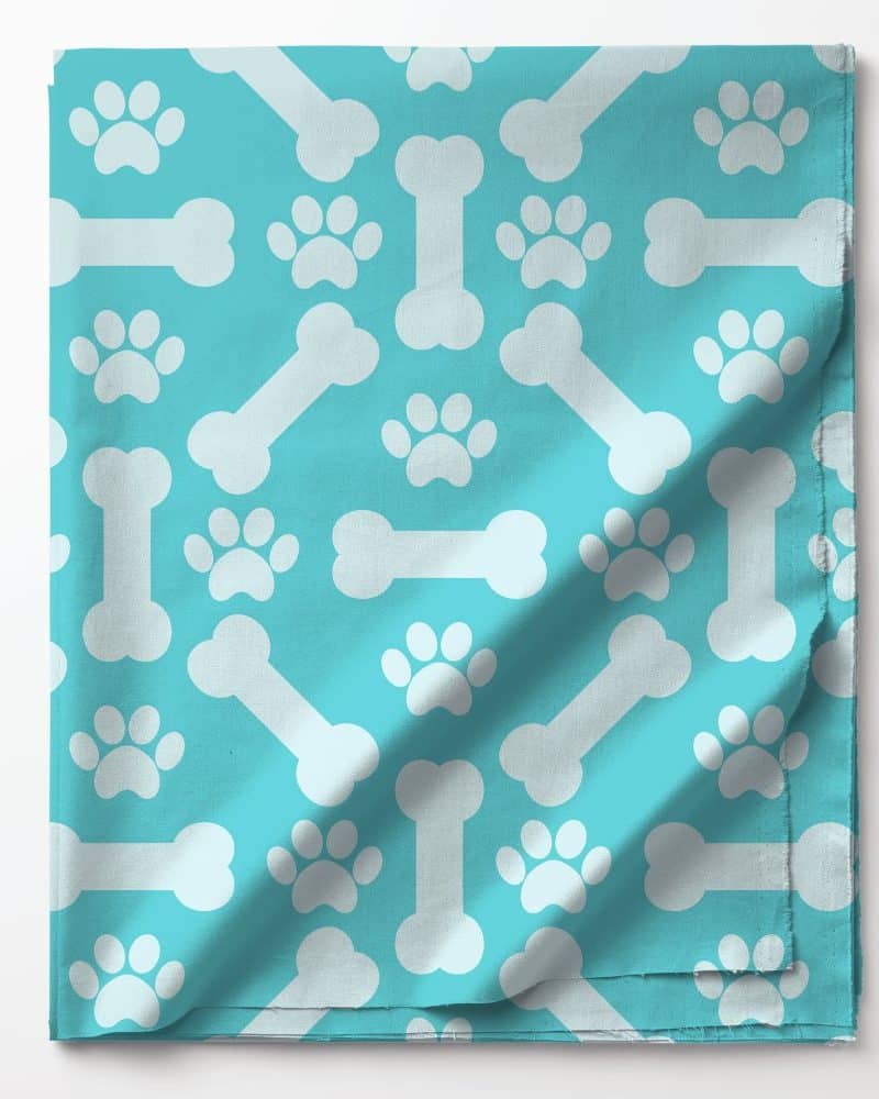 Teal fabric with a pattern of white bones and paw prints.
