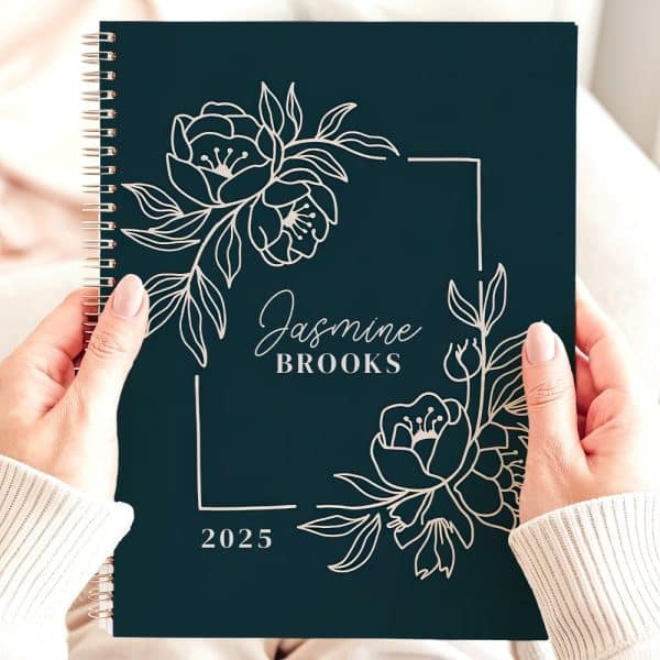 Dark Teal 2025 Spiral-Bound Planner With Silver Floral Design And The Name Jasmine Brooks.